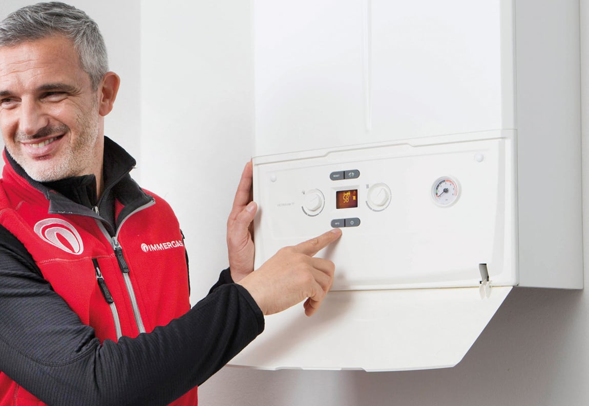 tecnico con brand immergas che sorride indicando una caldaia immergas di assitecnica srl